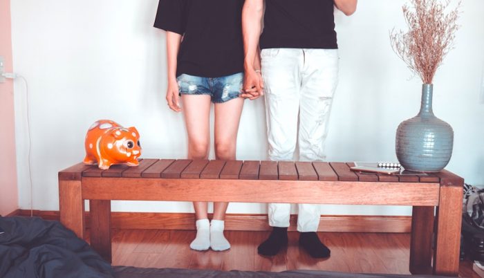 A couple standing holding hands in front of a coffee table