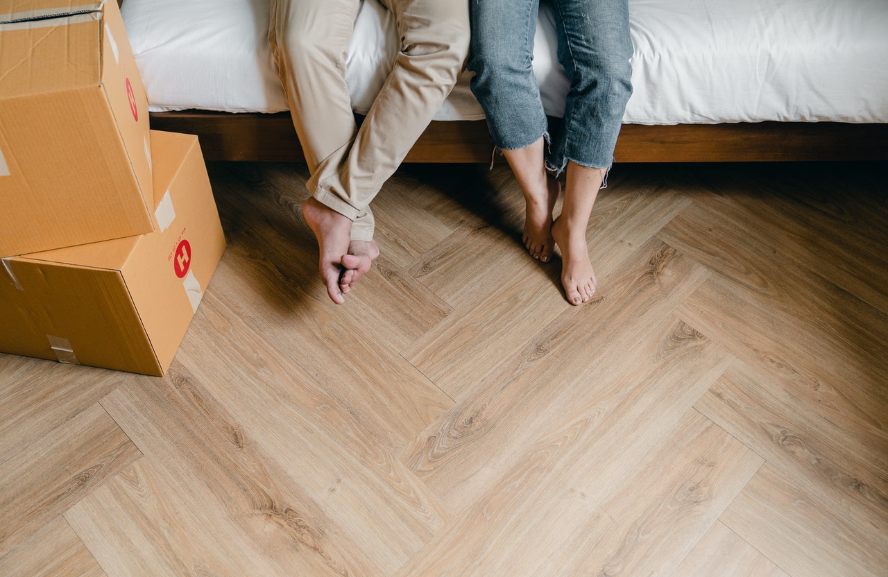 A couple just moved in, sitting on a bed