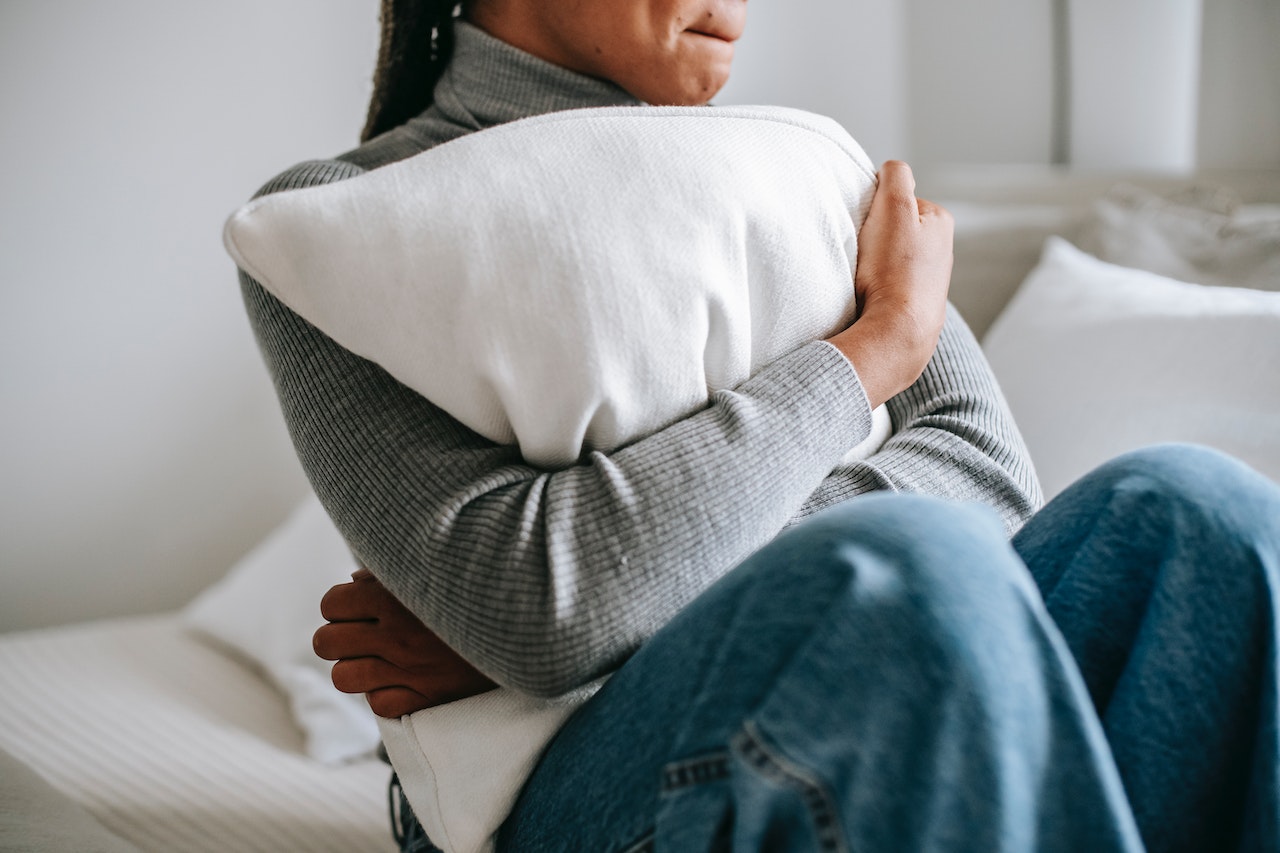A woman clutching a pillow with fear