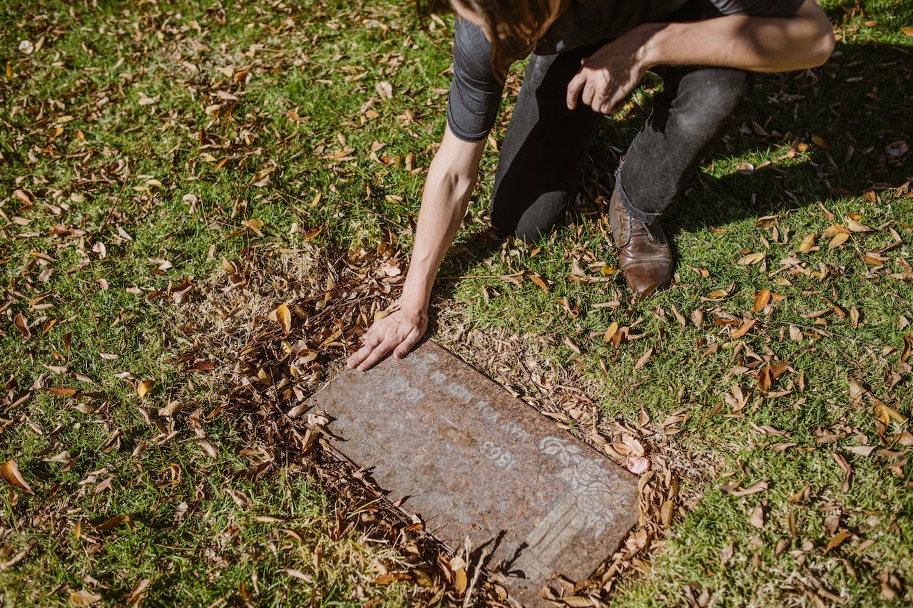 A man touching a gravestone of a loved one