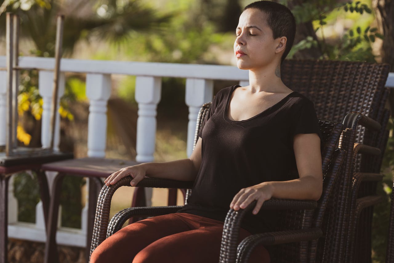 A woman in black top sitting in a brown chair