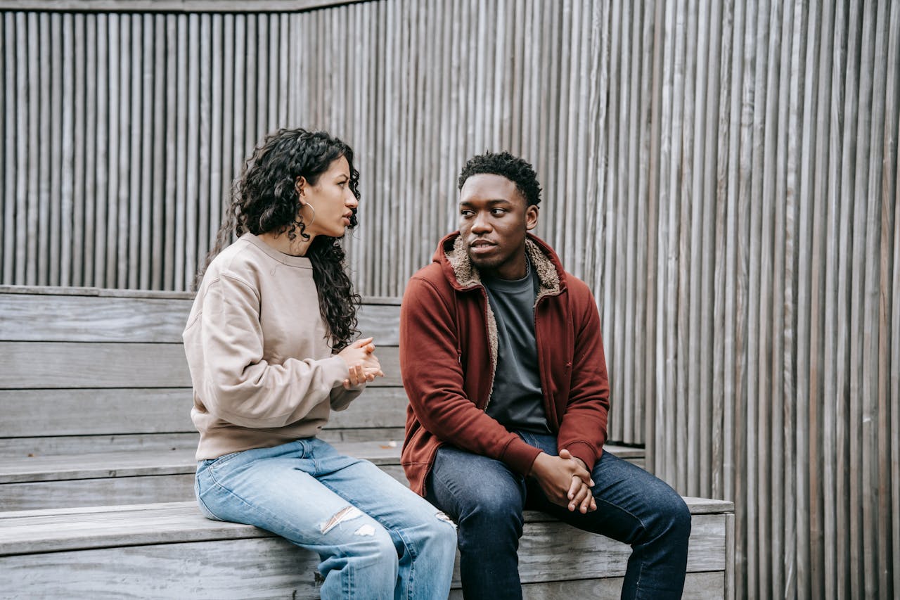 An interracial couple talking to each other while sitting