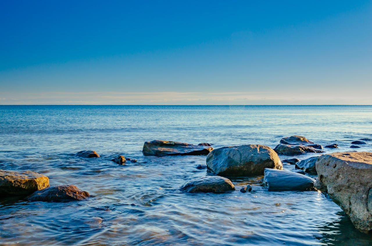 Rocks in the sea with blue horizon and sky