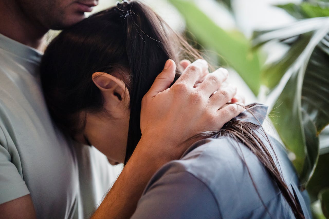 A woman leaning on a man's chest