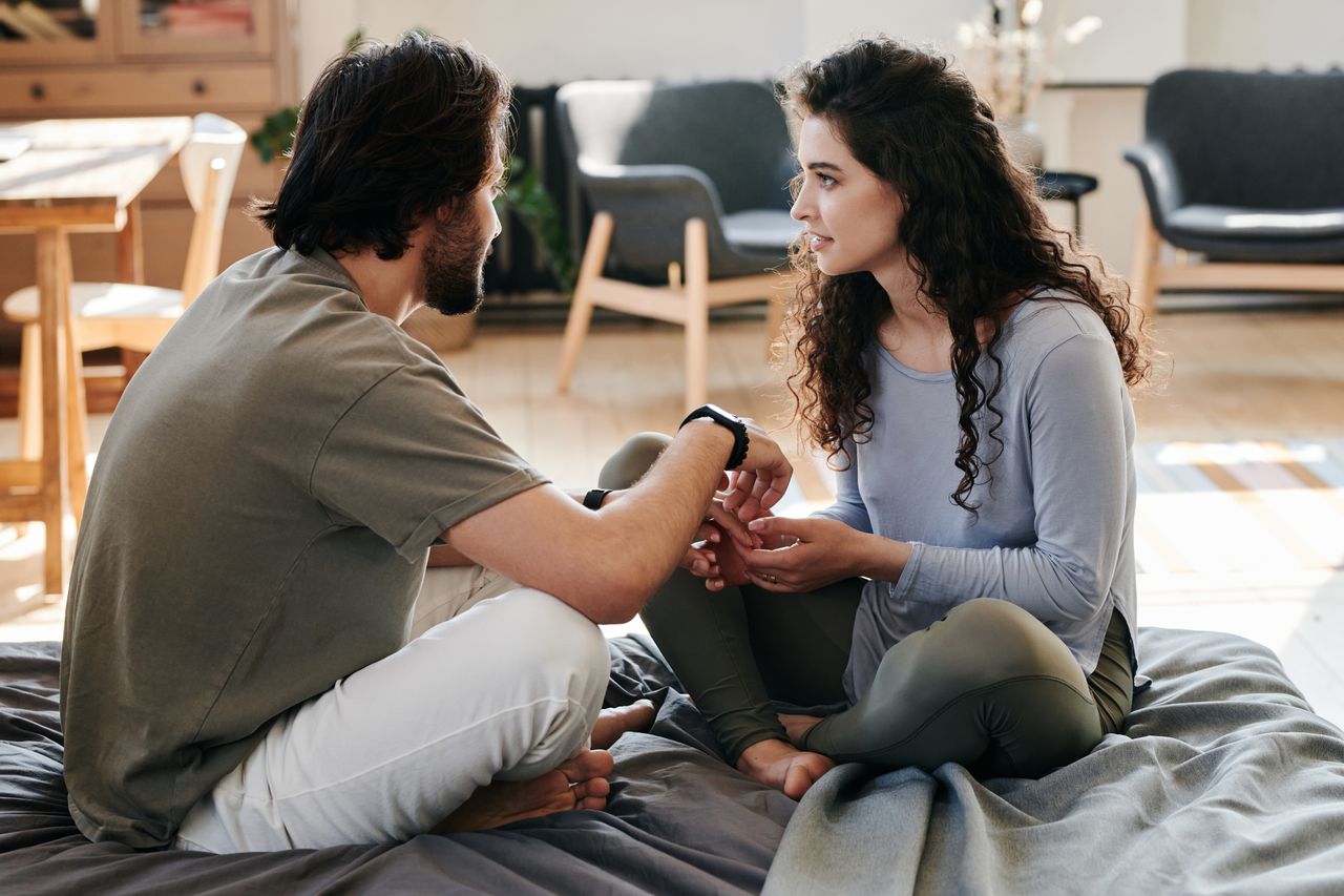 A couple sitting closely on the floor, opening up to each other